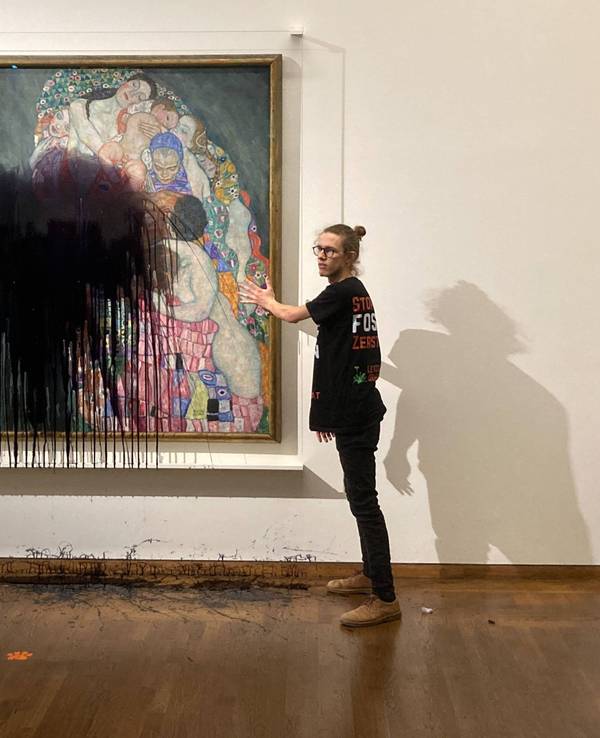 Ein Aktivist wirft schwarze Farbe auf ein Gemälde in einem Museum.