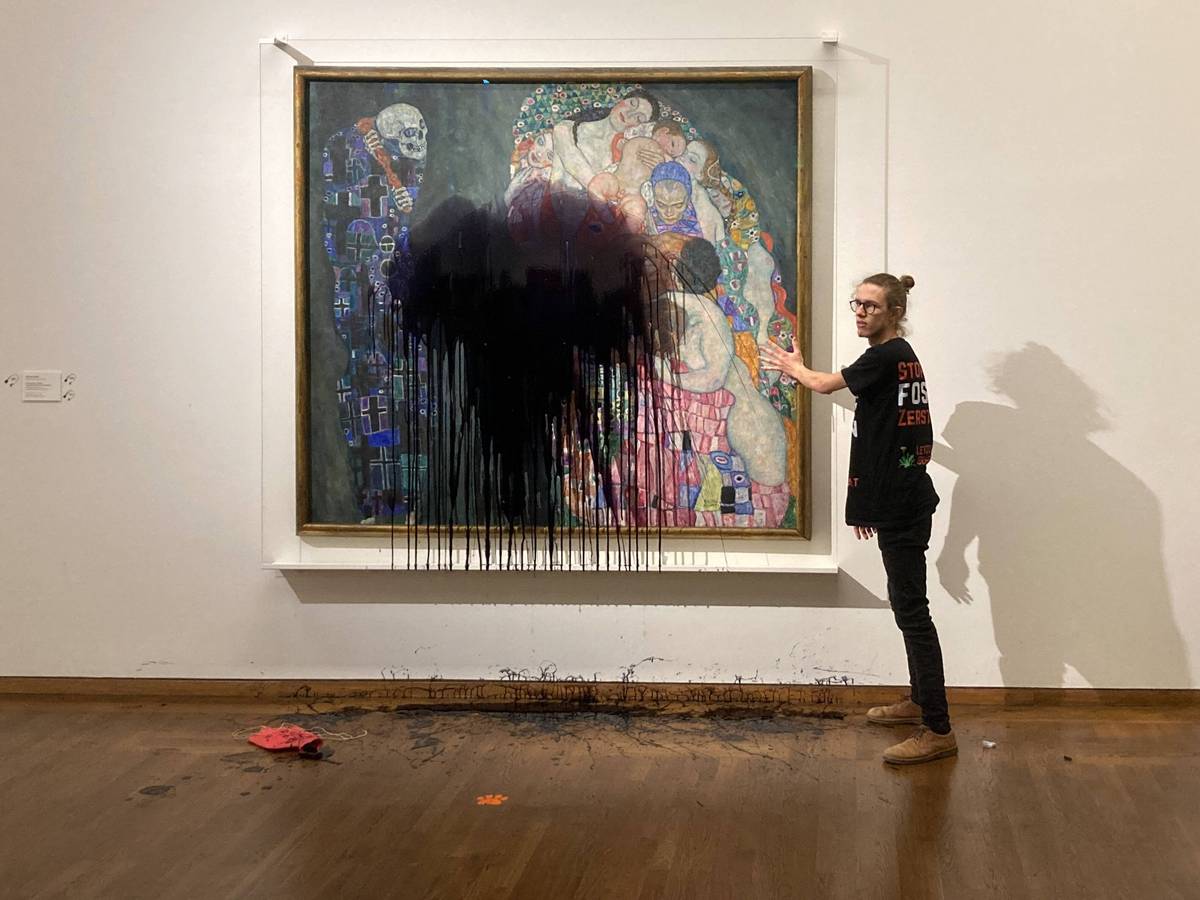 Ein Aktivist wirft schwarze Farbe auf ein Gemälde in einem Museum.