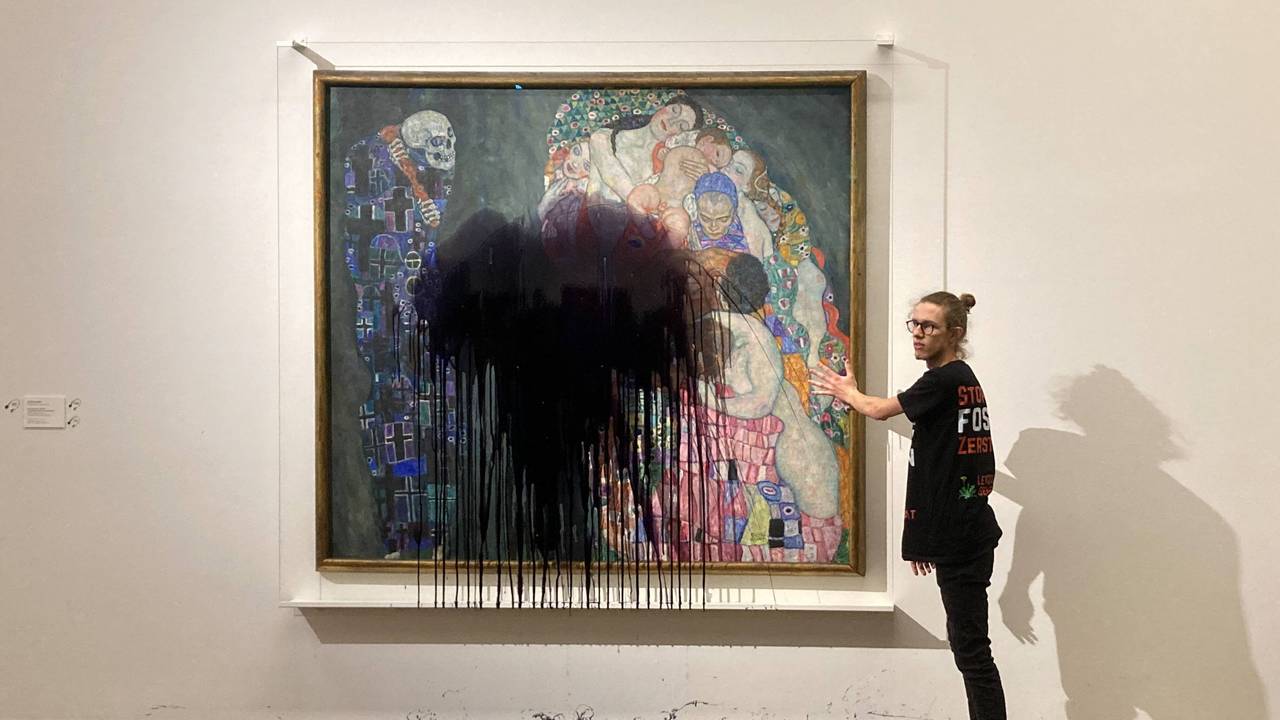 Ein Aktivist wirft schwarze Farbe auf ein Gemälde in einem Museum.