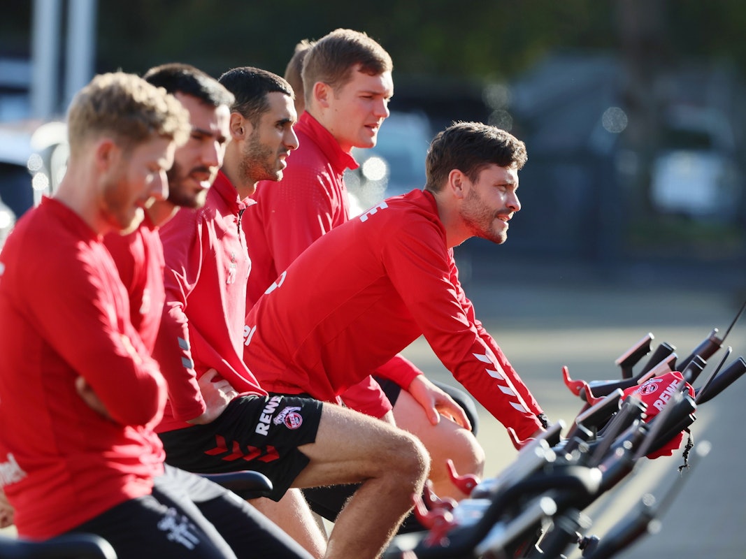 Jonas Hector fährt am Geißbockheim Fahrrad.
