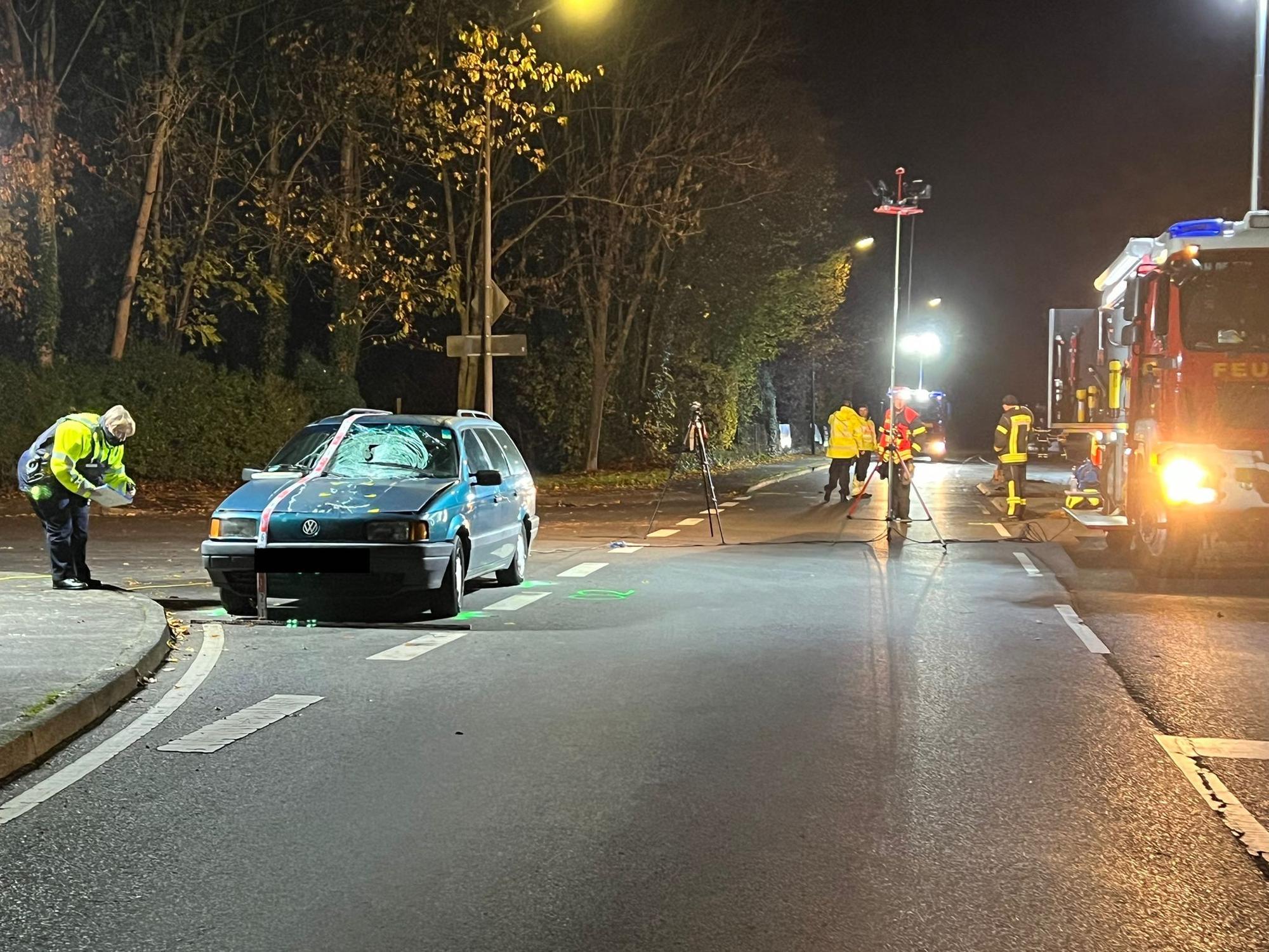 Beschädigtes Auto steht an einer Unfallstelle, daneben Autos der Feuerwehr. Eine Frau und ein Hund sind gestorben.