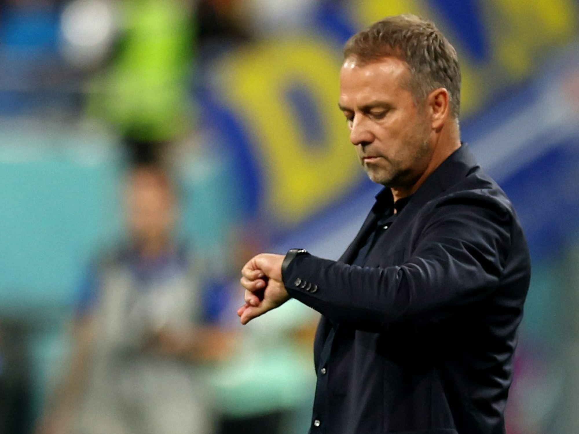 Hansi Flick schaut beim Spiel gegen Japan auf seine Armbanduhr.