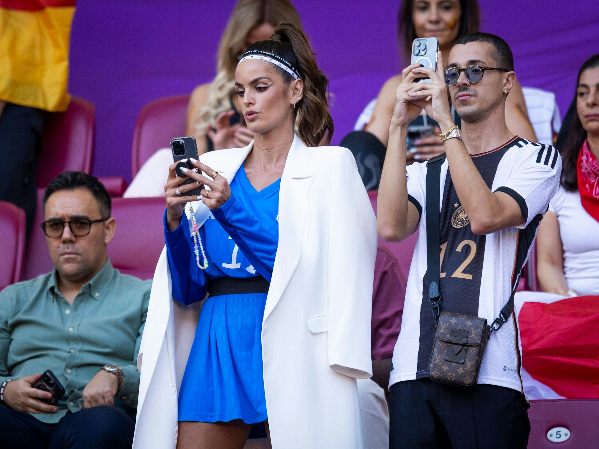 Izabel Goulart macht Fotos auf der Tribüne.