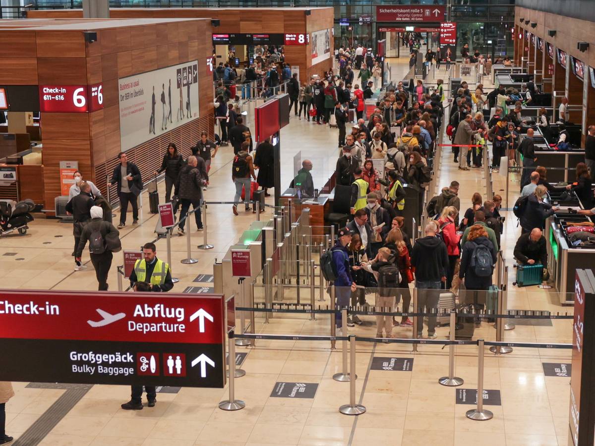 Reisende stehen in einer Schlange an der Sicherheitskontrolle im Terminal 1 des Flughafens BER.