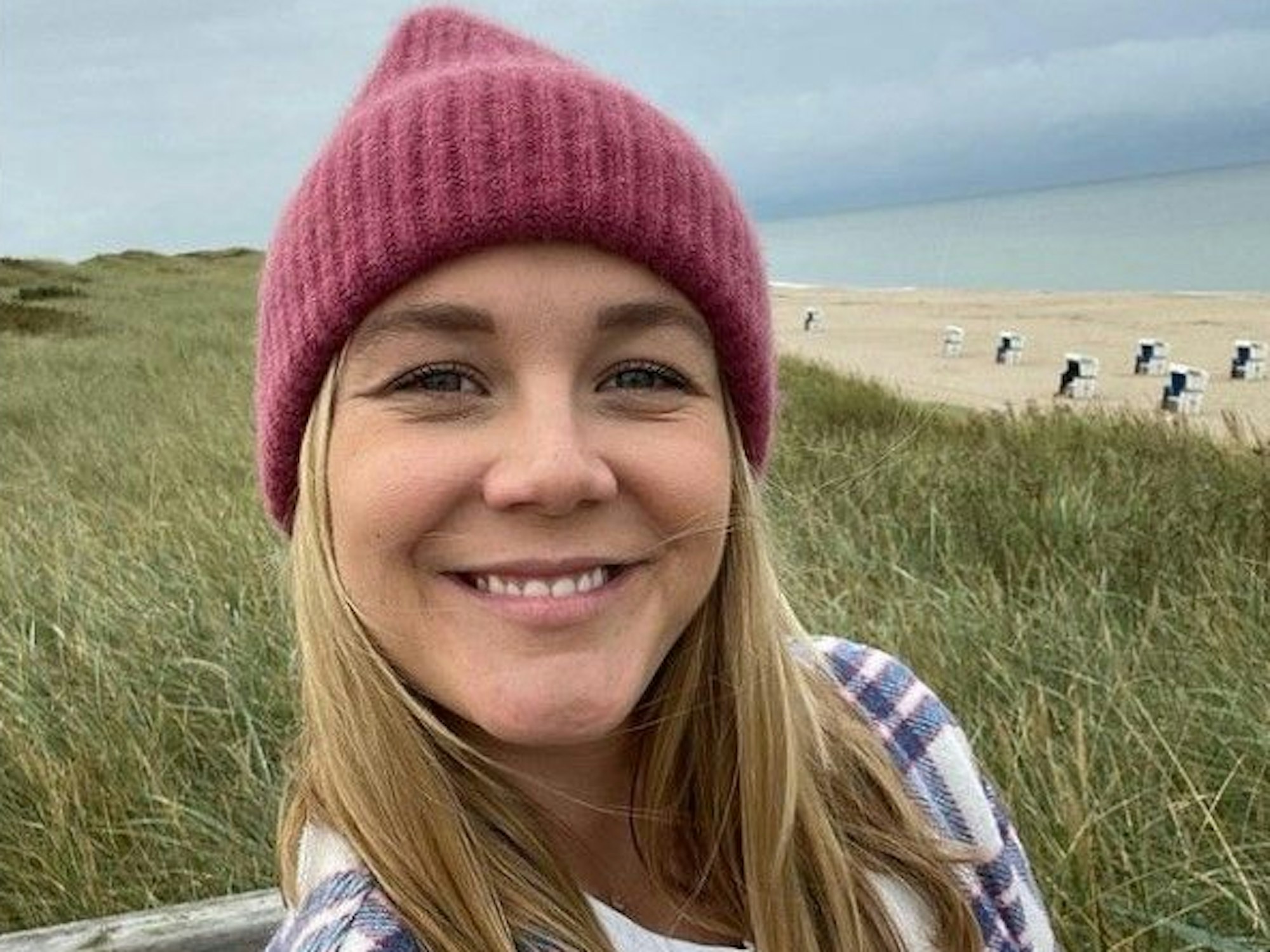 Alina Merkau, hier auf einem Instagram-Selfie vom 22. September, sitzt auf einer Bank. Im Hintergrund sind ein Strand und das offene Meer zu sehen.