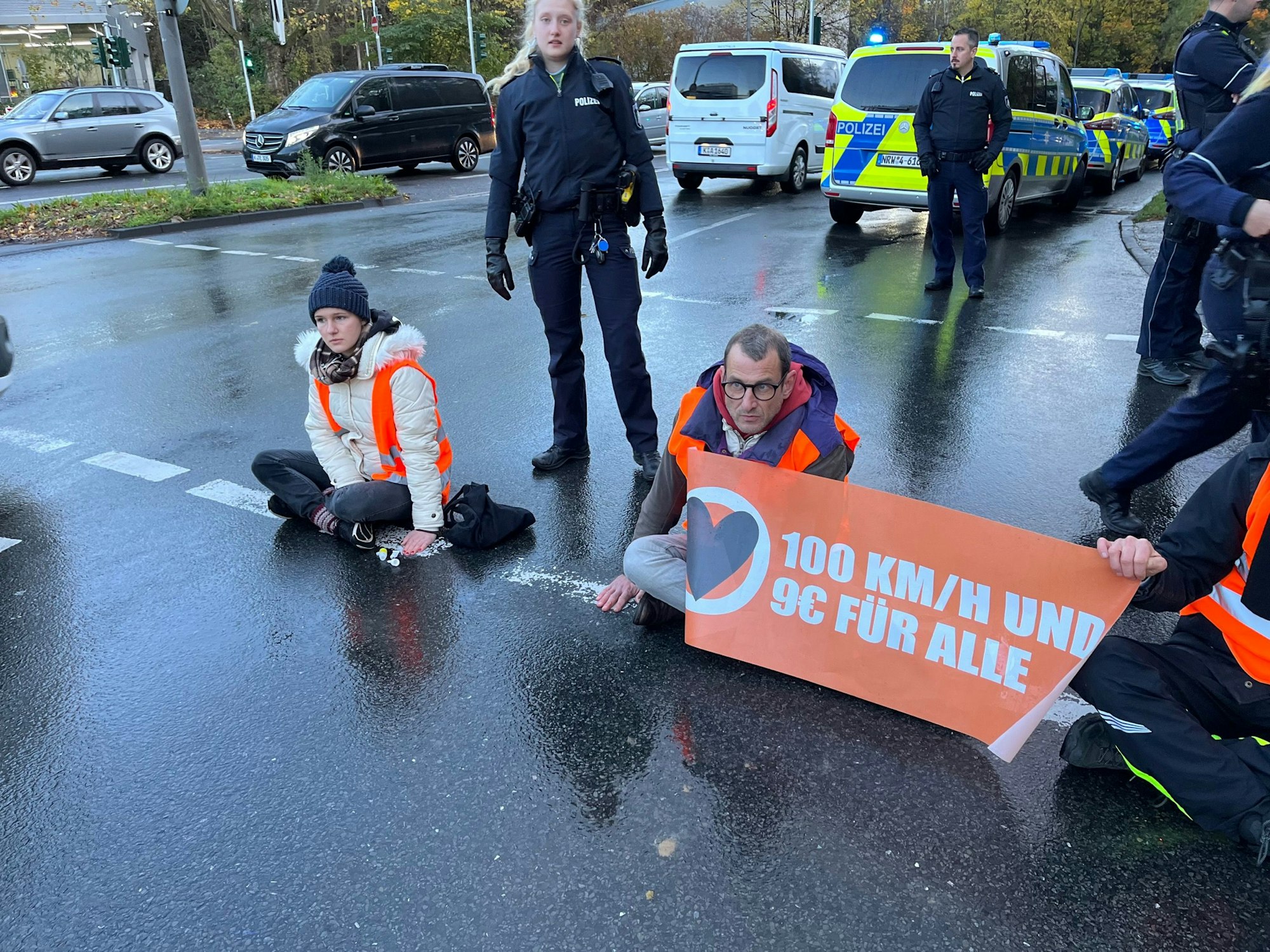 Beamte und Beamtinnen der Polizei stehen rund um den Ort des „Letzte Generation“-Protests auf der Inneren Kanalstraße in Köln am 24. November 2022.