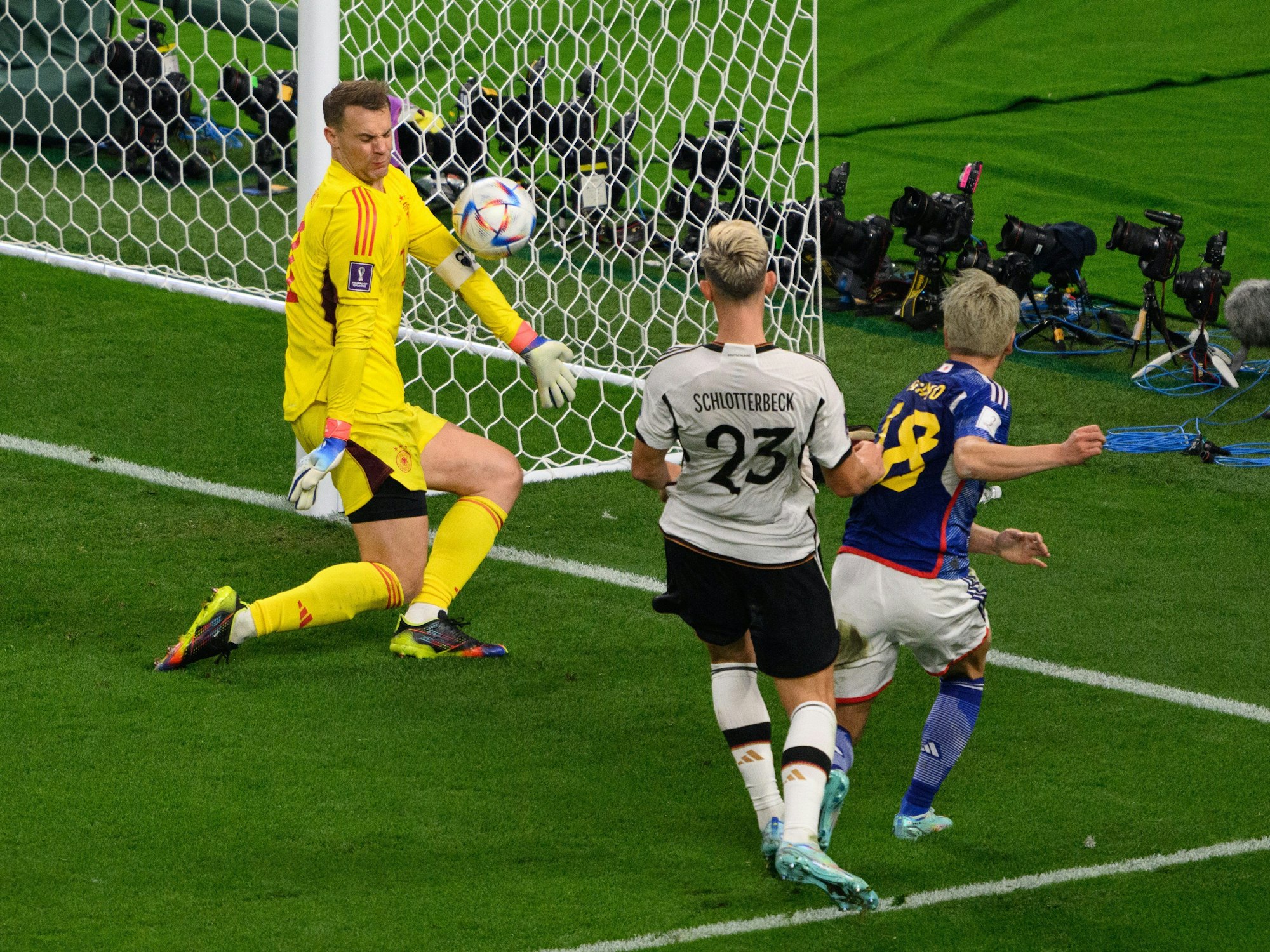Japans Takuma Asano (r) trifft gegen Deutschlands Nico Schlotterbeck (M) und Deutschlands Torwart Manuel Neuer zum 1:2.