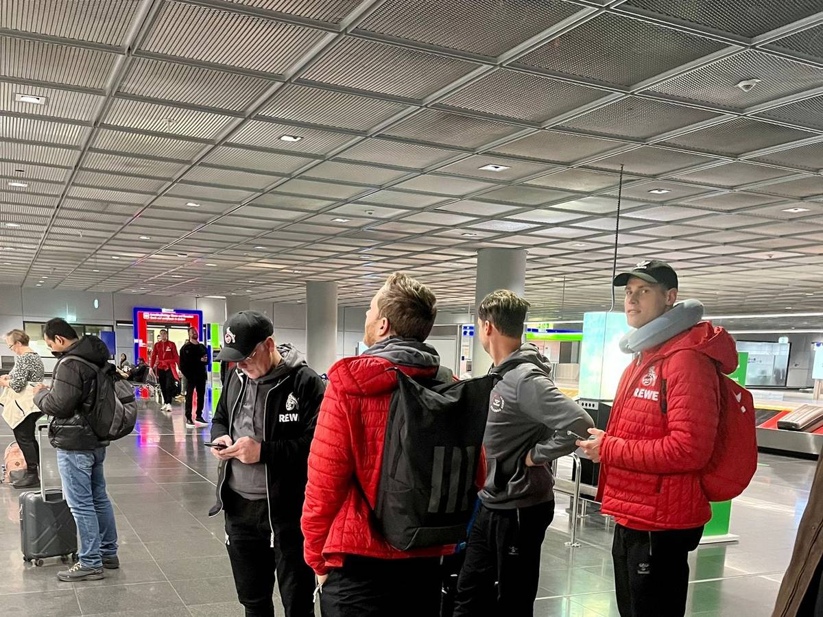 Profis und Betreuer des 1. FC Köln stehen am Donnerstag am Frankfurter Flughafen.