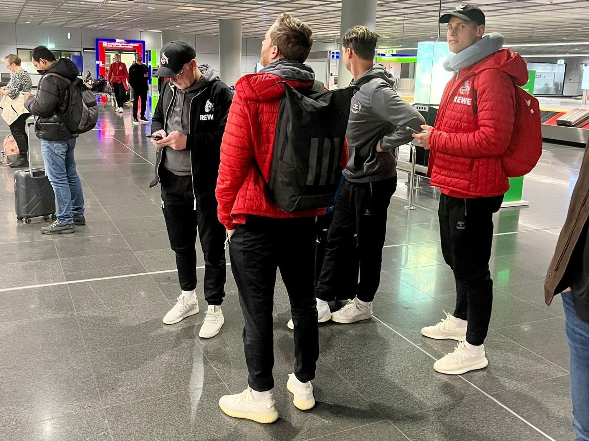 Profis und Betreuer des 1. FC Köln stehen am Donnerstag am Frankfurter Flughafen.