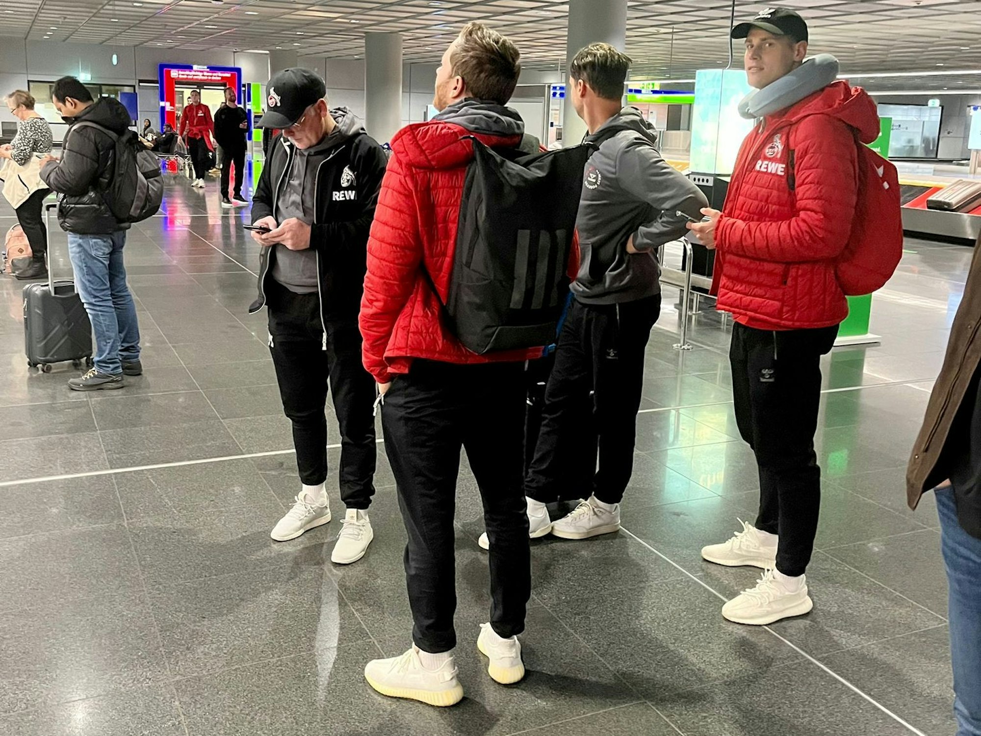 Profis und Betreuer des 1. FC Köln stehen am Donnerstag am Frankfurter Flughafen.