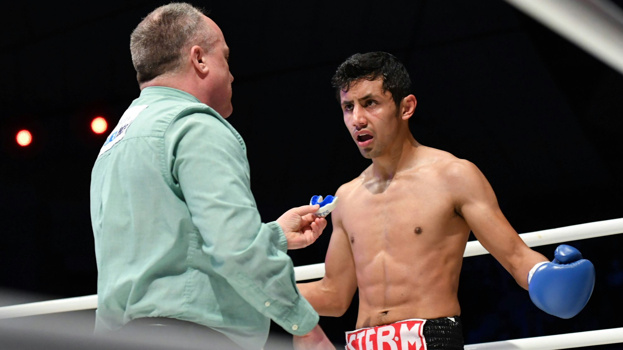 Der Schiedsrichter gibt Box-Star Moises Fuentes seinen Mundschutz zurück.