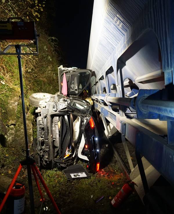 Zerstörtes Auto liegt auf der Seite und sieht zerstört aus. Es wurde von einem Güterzug erfasst.