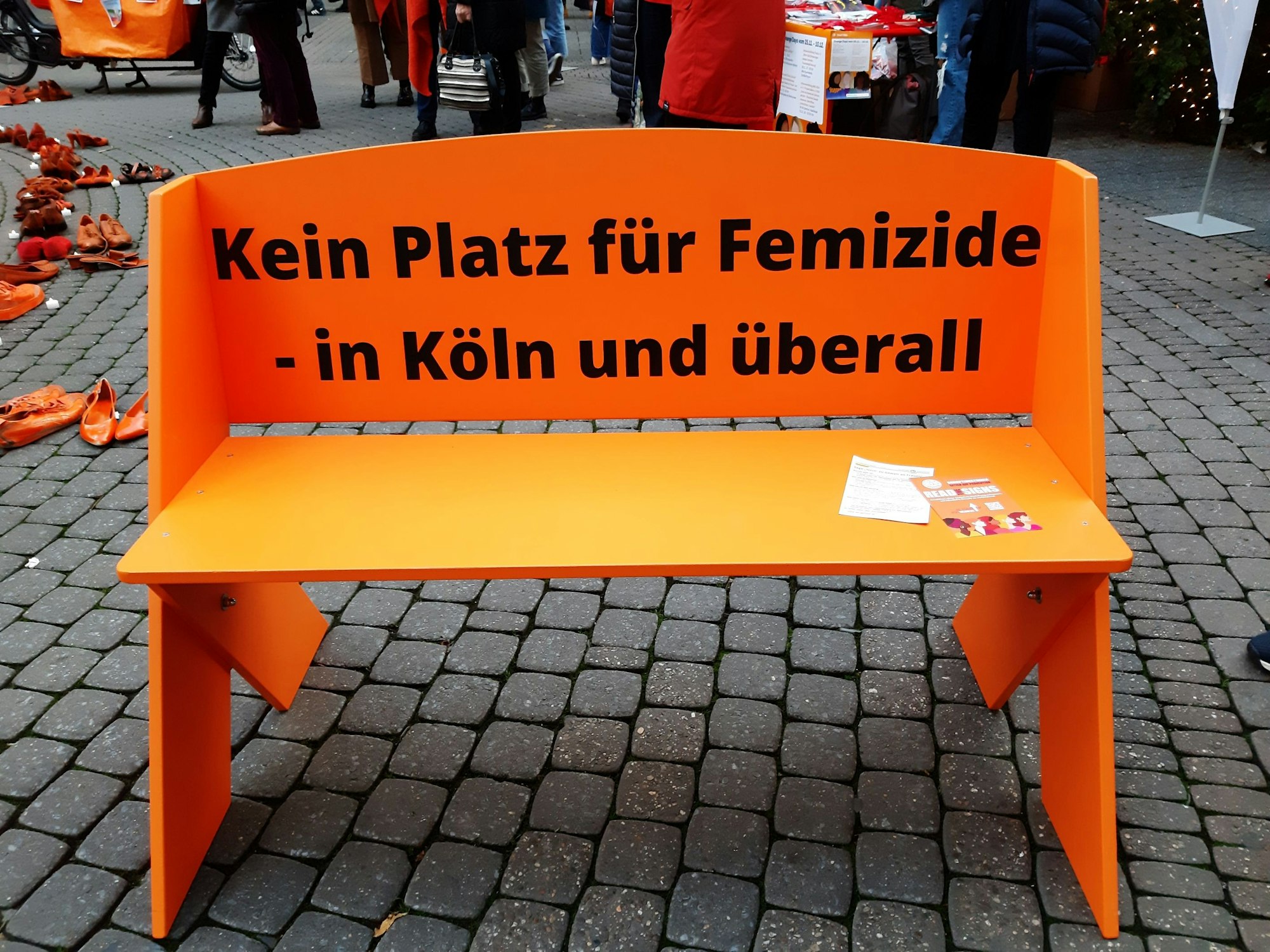 Eine orangefarbene Bank mit der Aufschrift „Kein Platz für Femizide – in Köln und überall“ wurde auf der Schildergasse aufgestellt.