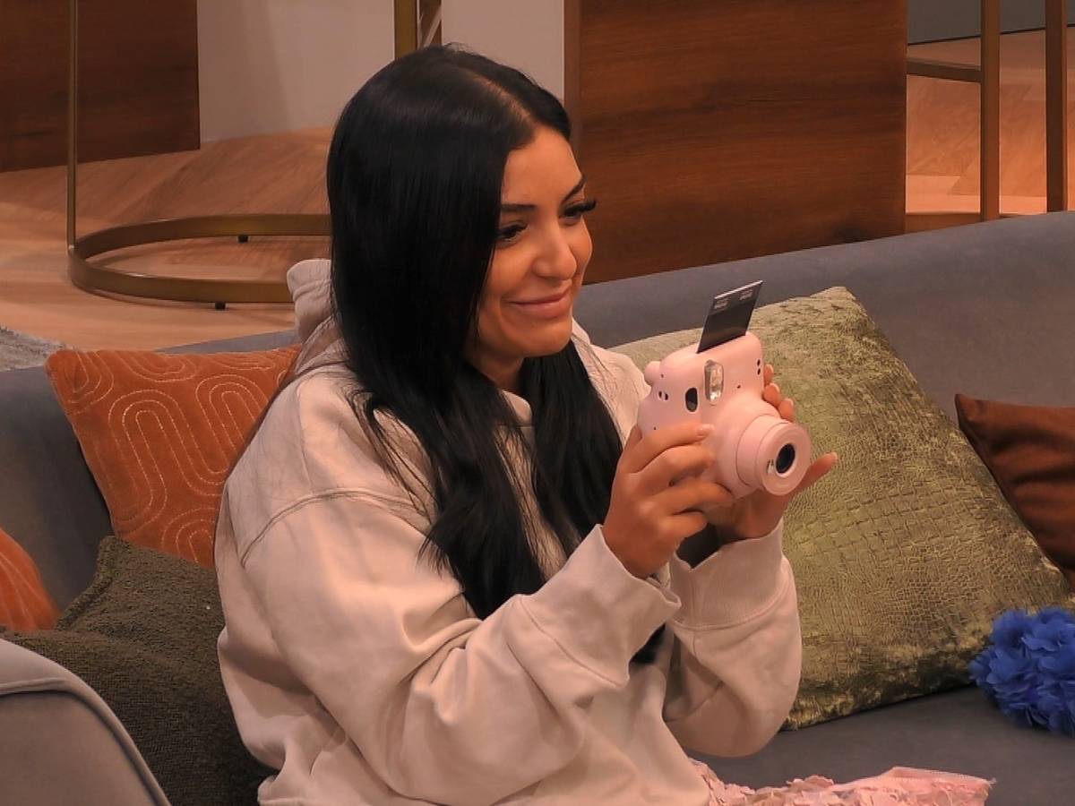 Jennifer Iglesias hält eine Polaroid-Kamera in der Hand.