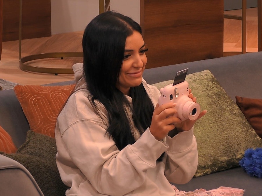 Jennifer Iglesias hält eine Polaroid-Kamera in der Hand.