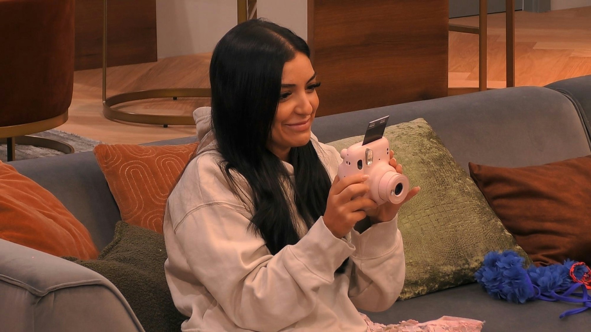 Jennifer Iglesias hält eine Polaroid-Kamera in der Hand.