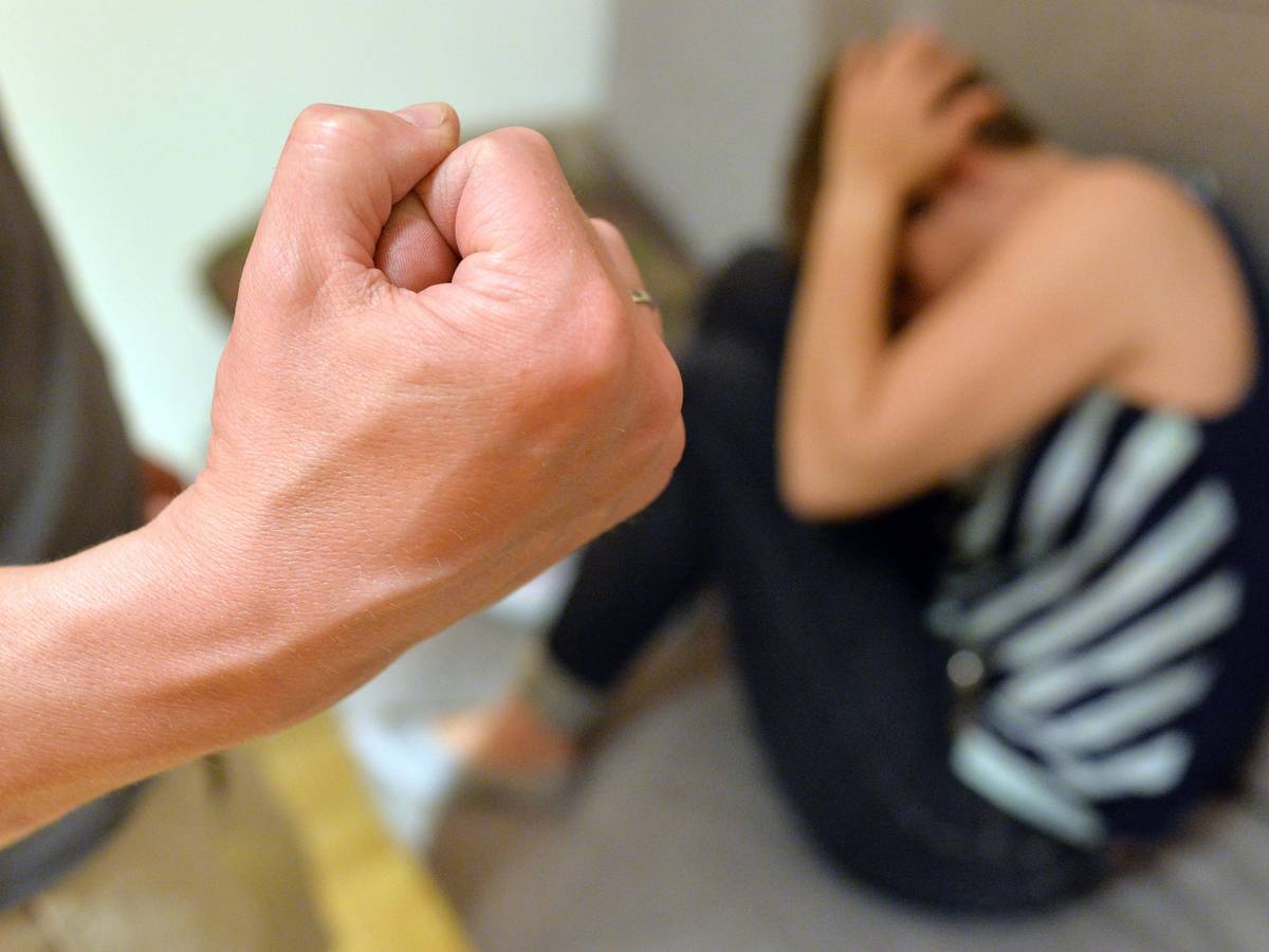 Eine Frau versucht, sich vor der Gewalt eines Mannes zu schützen (gestellte Szene).