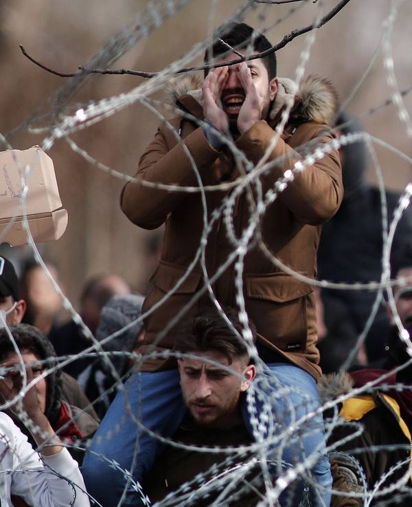 Migranten und Flüchtlinge versammeln sich hinter einem Drahtzaun an der Grenze zwischen Griechenland und der Türkei in der Nähe des geschlossenen Grenzübergangs Kastanies.