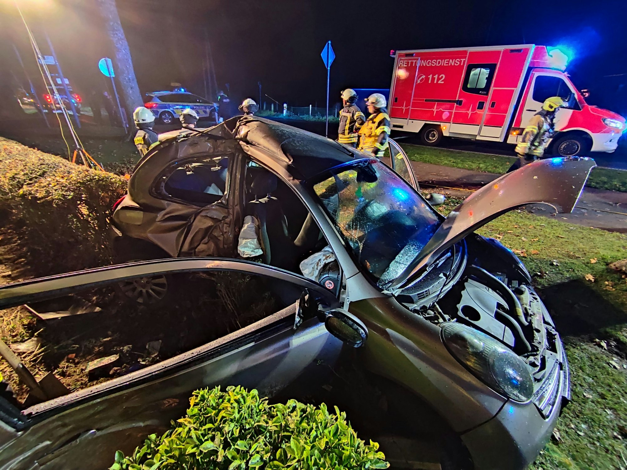 Beifahrerseite eines Unfallautos sieht stark zerstört aus. Die Türen und die Motorhaube sind geöffnet.