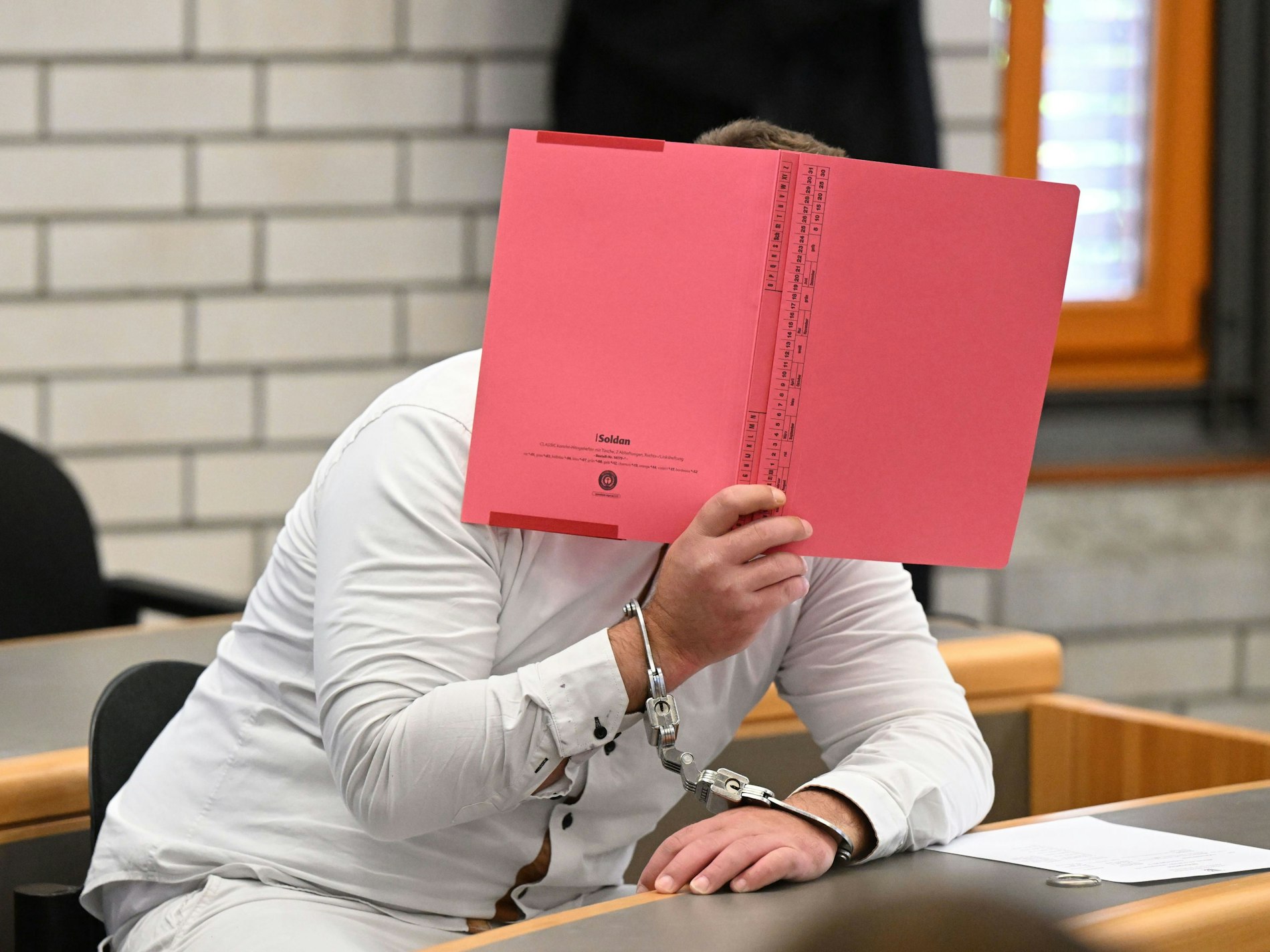 Der Angeklagte im Prozess wegen Mordes an einer Sechsjährigen und Störung der Totenruhe wartet in einem Verhandlungssaal im Landgericht Baden-Baden auf den Prozessbeginn.