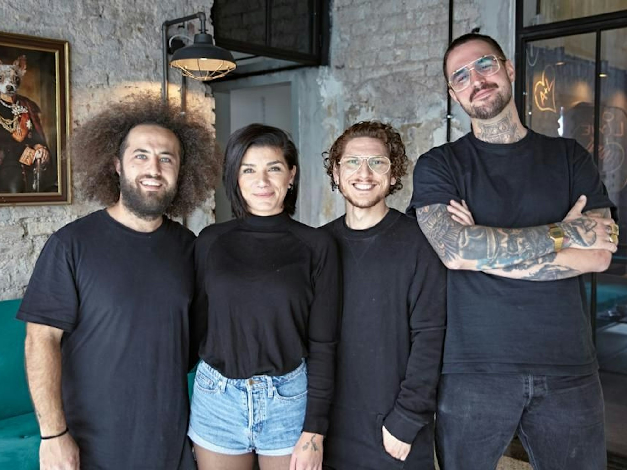 Vier Personen posieren in einem Frieseurgeschäft.