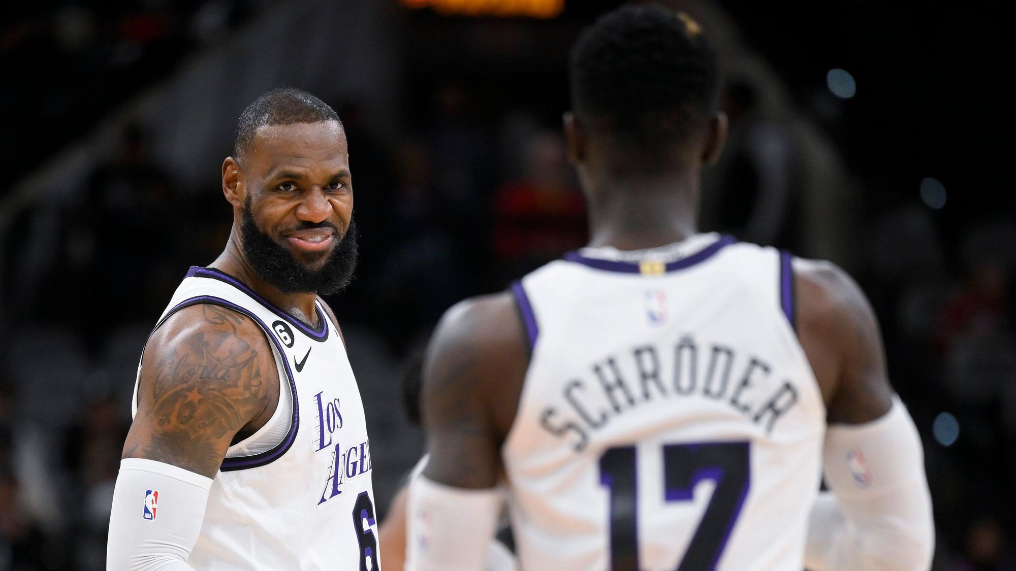 LeBron James lächelt im NBA-Spiel in San Antonio Teamkollege Dennis Schröder von den Los Angeles Lakers an.