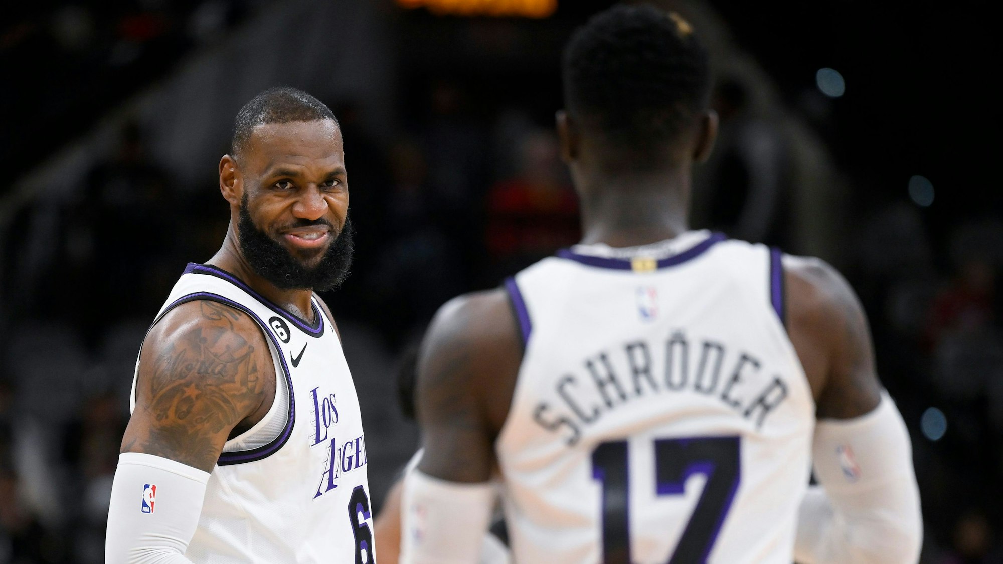 LeBron James lächelt im NBA-Spiel in San Antonio Teamkollege Dennis Schröder von den Los Angeles Lakers an.