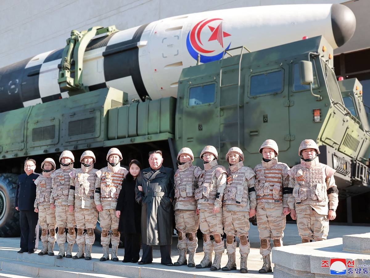 Nordkoreas Machthaber Kim Jong-un posiert mit Soldaten und seiner Tochter vor einer Rakete.
