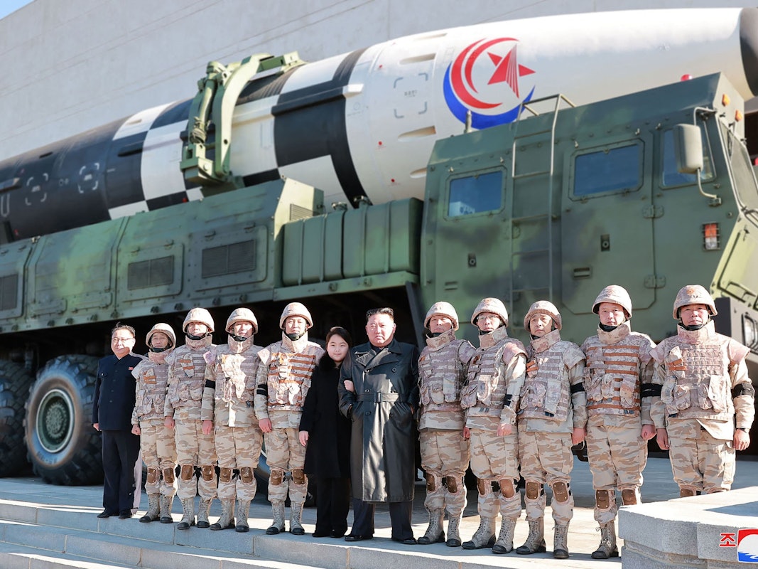 Nordkoreas Machthaber Kim Jong-un posiert mit Soldaten und seiner Tochter vor einer Rakete.