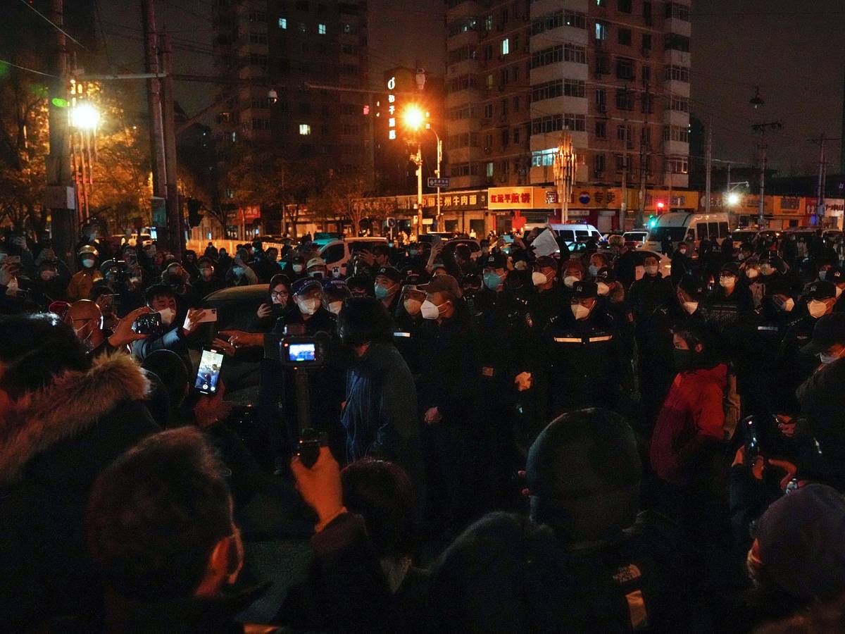 Demonstrierende stoßen mit Polizisten während einer Demonstration zusammen. In China hat die strenge Corona-Politik am Wochenende zu den größten Protesten seit Jahrzehnten geführt.