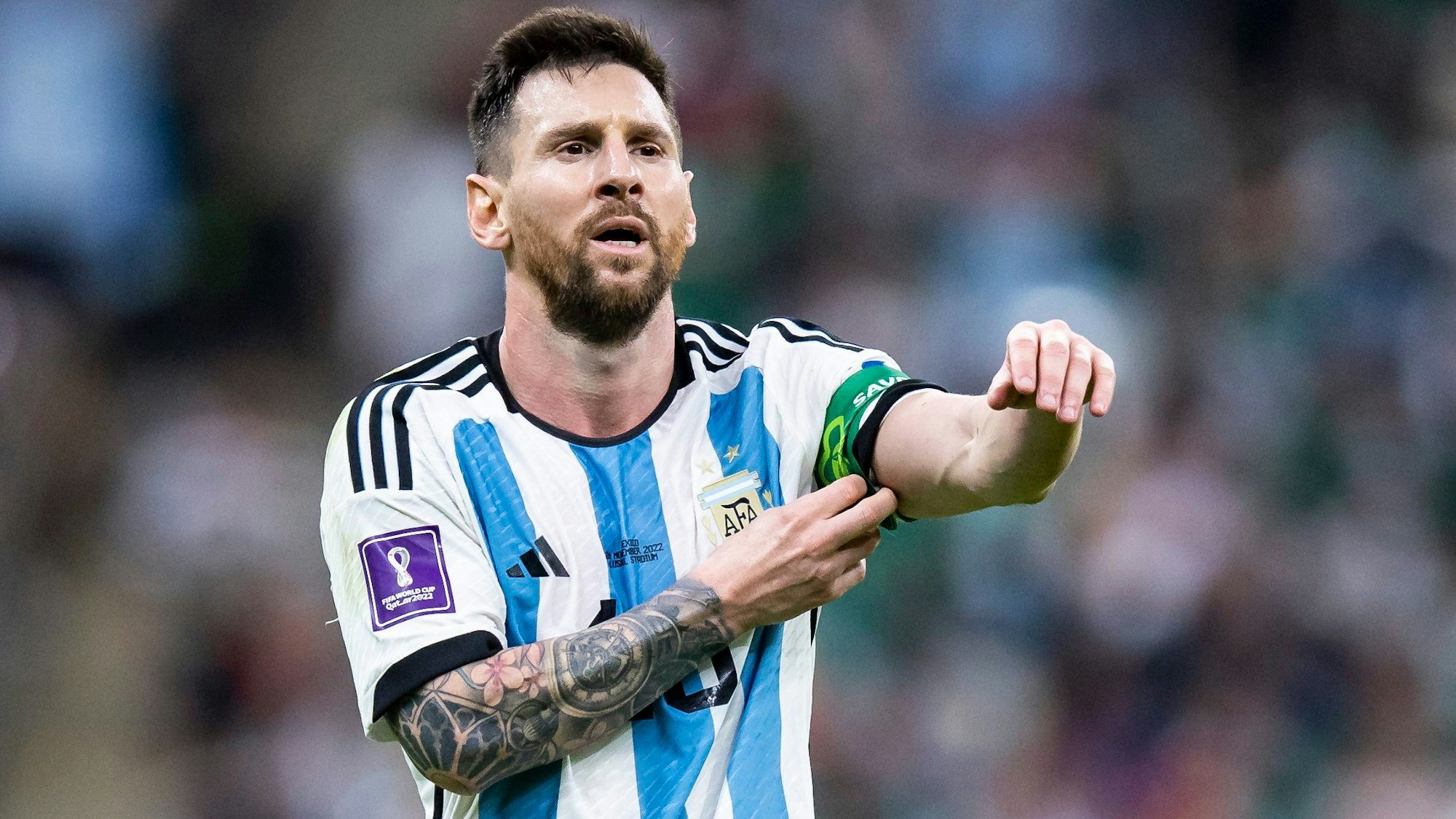 Lionel Messi rückt bei einem WM-Spiel mit Argentinien seine Kapitänsbinde zurecht
