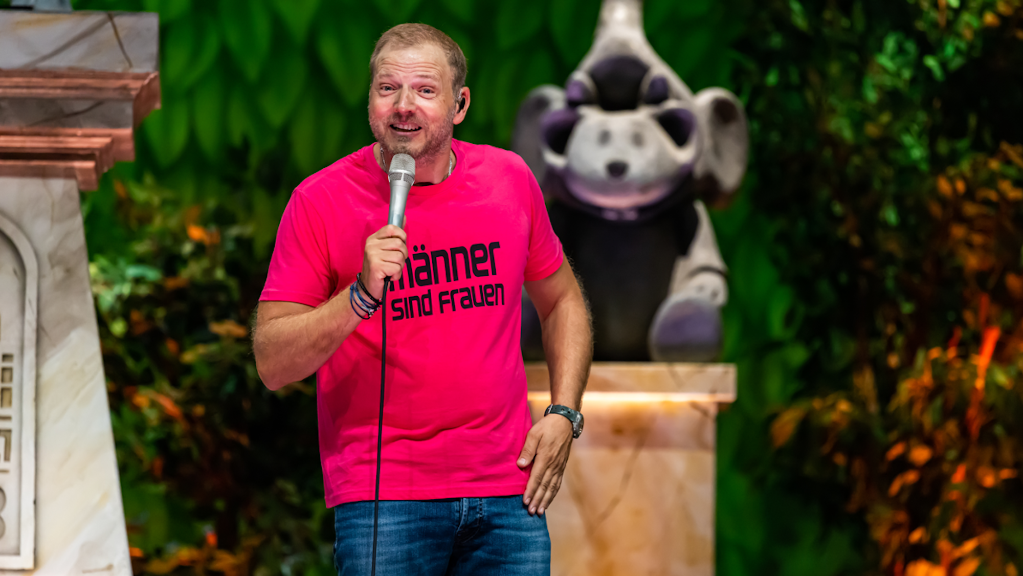 Mario Barth performt in einem pinken T-Shirt auf der Bühne.