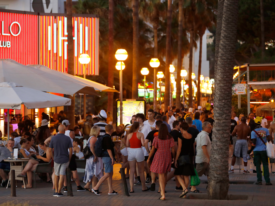 Touristen und Partygäste tummeln sich auf der Promenade von Arenal.