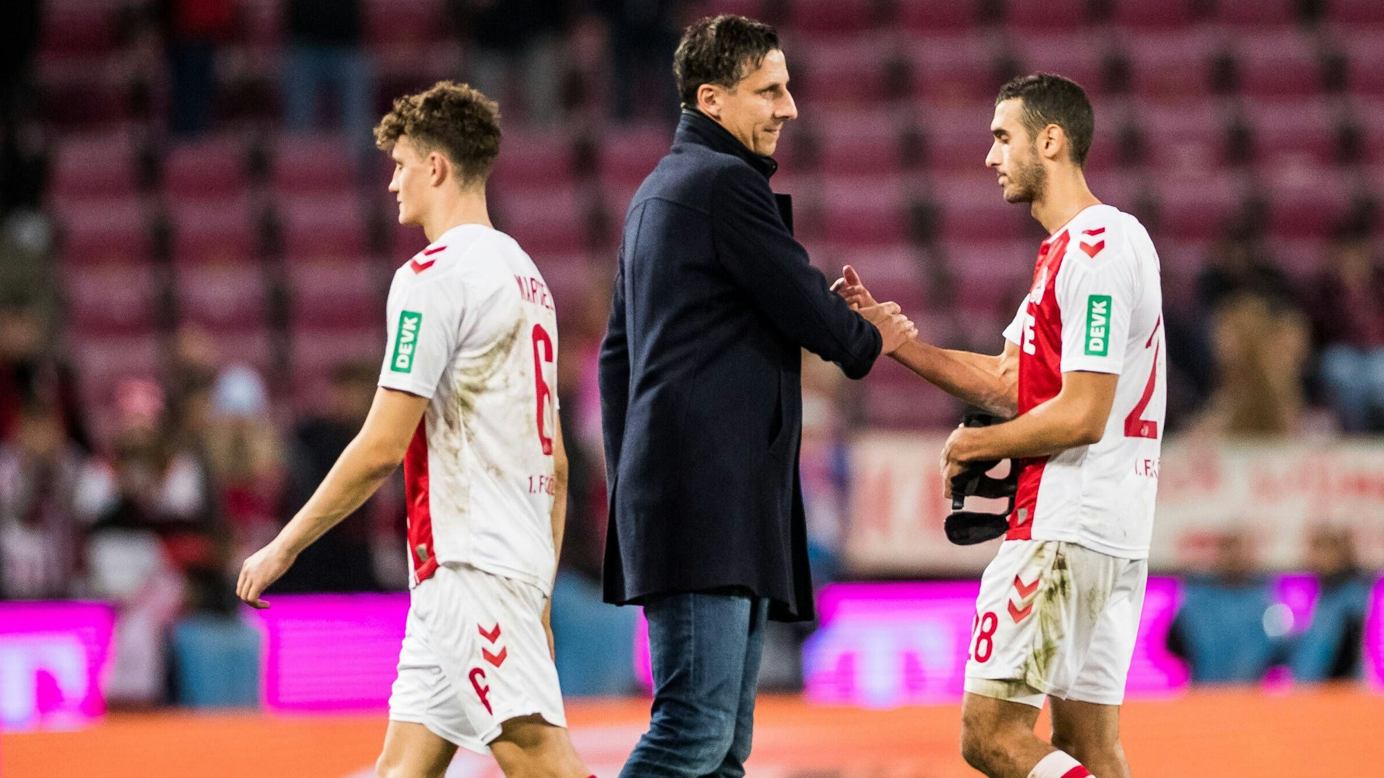 Christian Keller und Ellyes Skhiri klatschen nach der Niederlage des 1. FC Köln gegen Bayer Leverkusen ab.