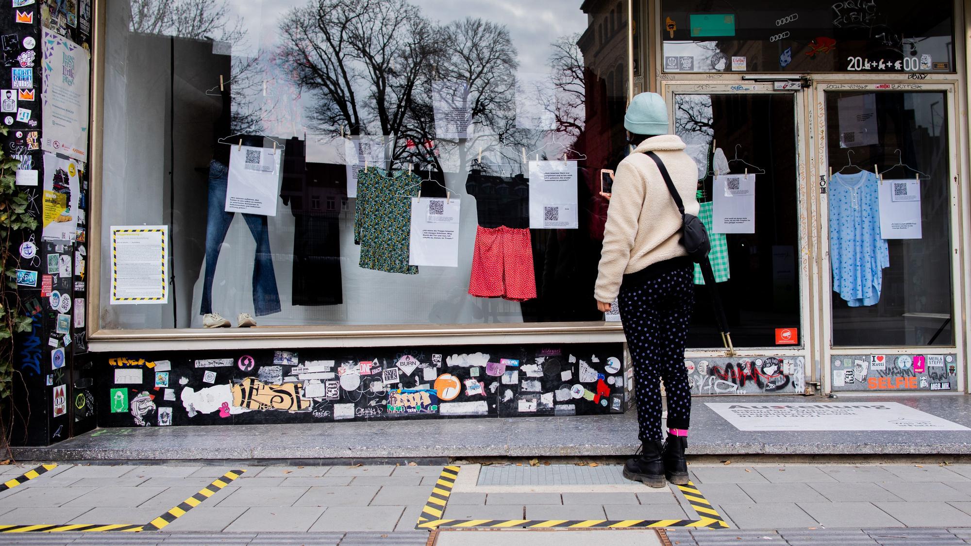 Eine Frau steht vor einem Schaufenster.