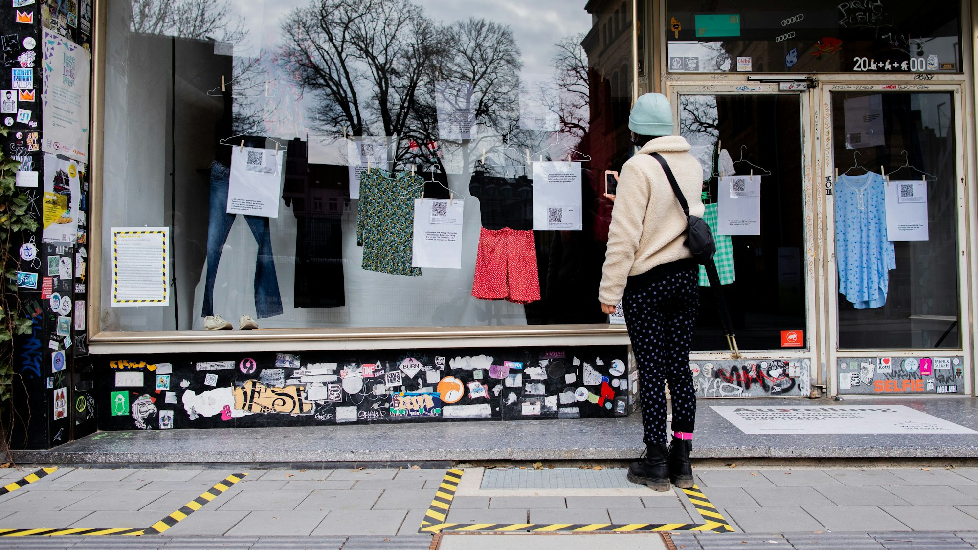 Eine Frau steht vor einem Schaufenster.