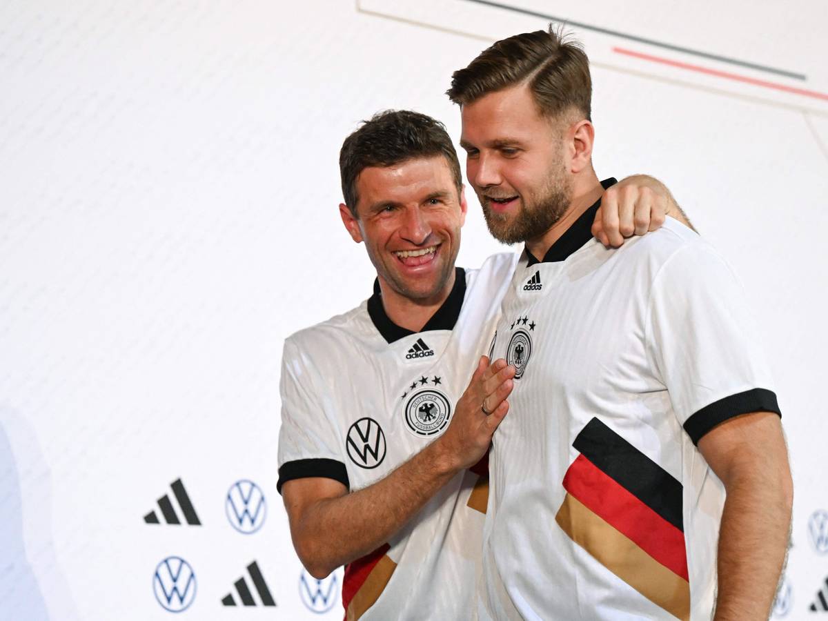 Thomas Müller und Niclas Fuellkrug scherzen nach der Pressekonferenz miteinander.