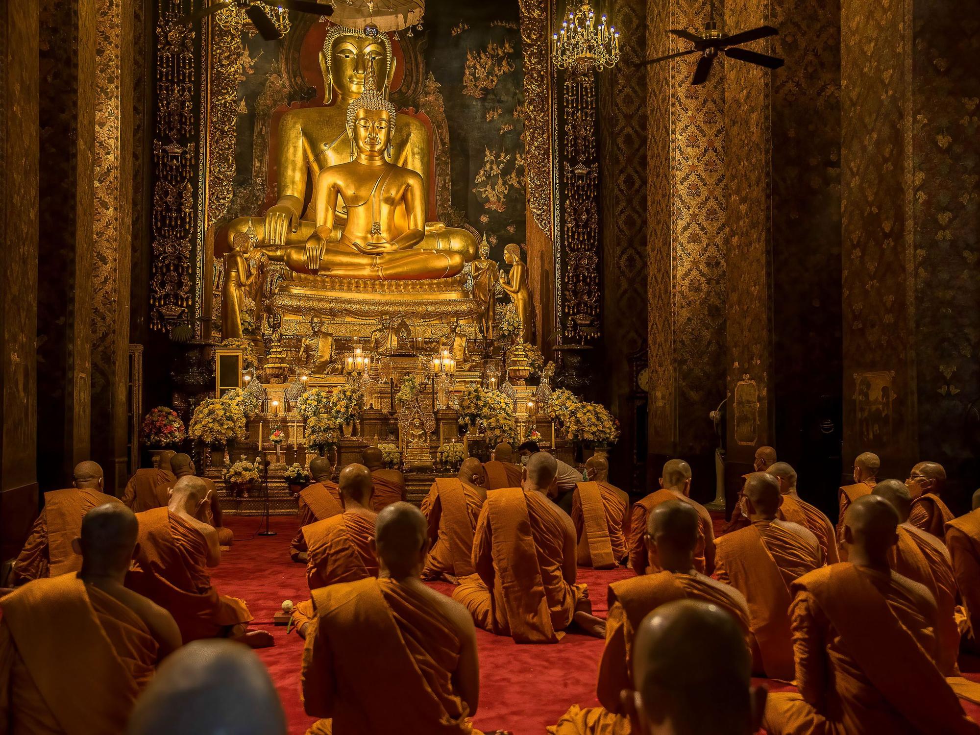 Thailändische buddhistische Mönche beten vor einer Buddha-Statue während der Makha-Bucha Feier im Tempel Bowonniwet Vihara.