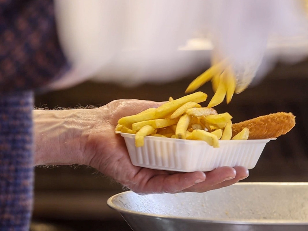 Imbisse und Kioske sind von der neuen Mehrwegangebotspflicht zunächst ausgenommen. Das Symbolfoto von März 2022 zeigt einen Mann in einer fahrbaren Imbissbude.