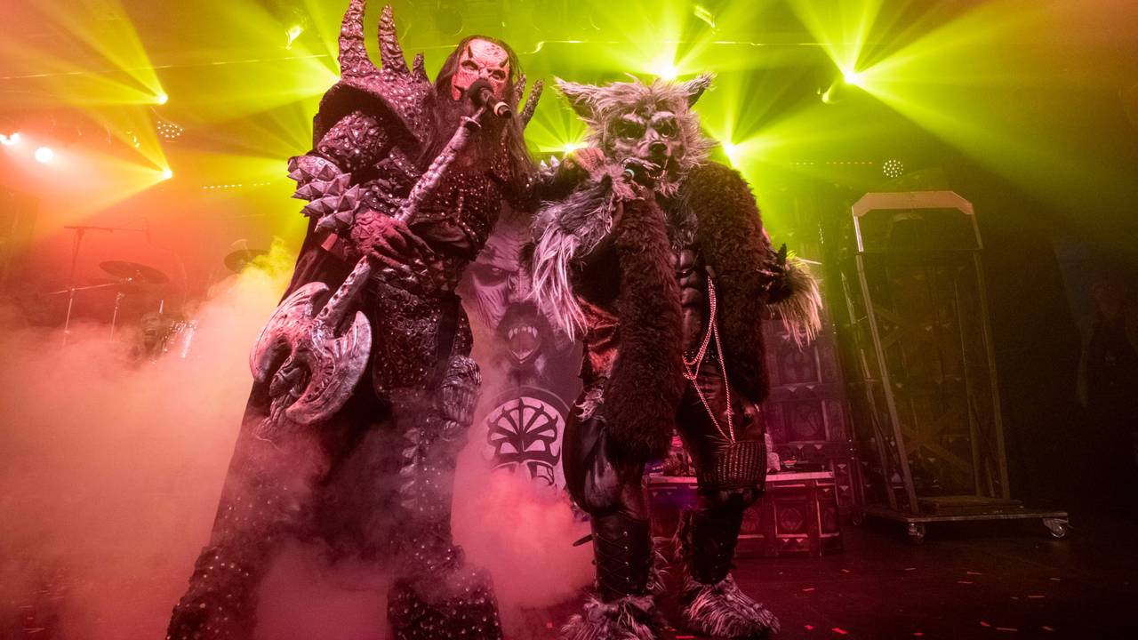 Der Sänger von Lordi und ein Mann im Werwolf-Kostüm stehen mit Mikrofonen auf der Bühne und singen.