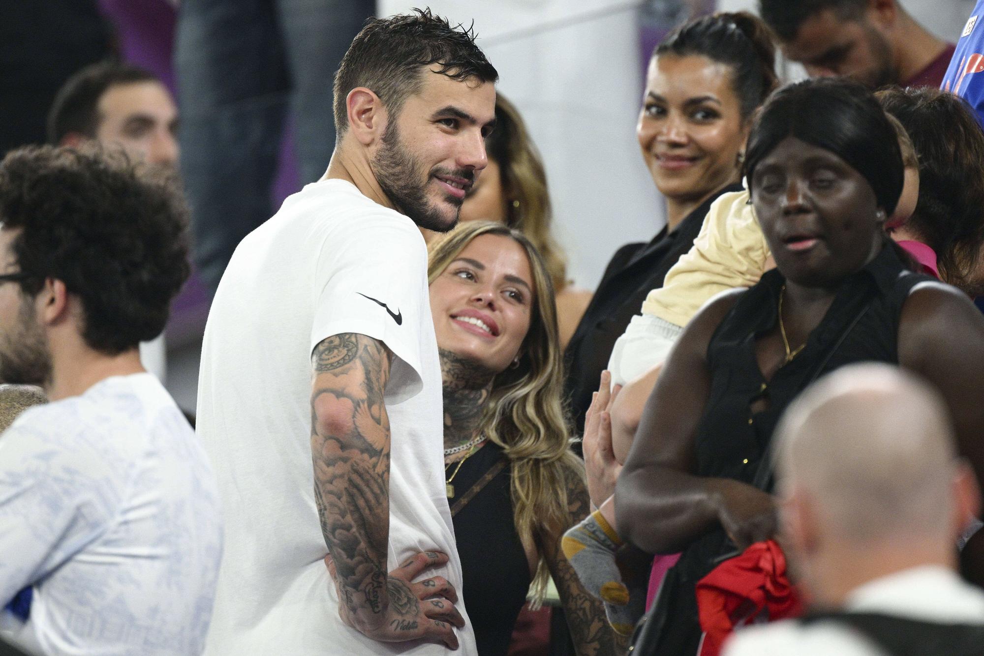 Theo Hernández und Partnerin Zoe Cristofoli lachen auf der Tribüne.