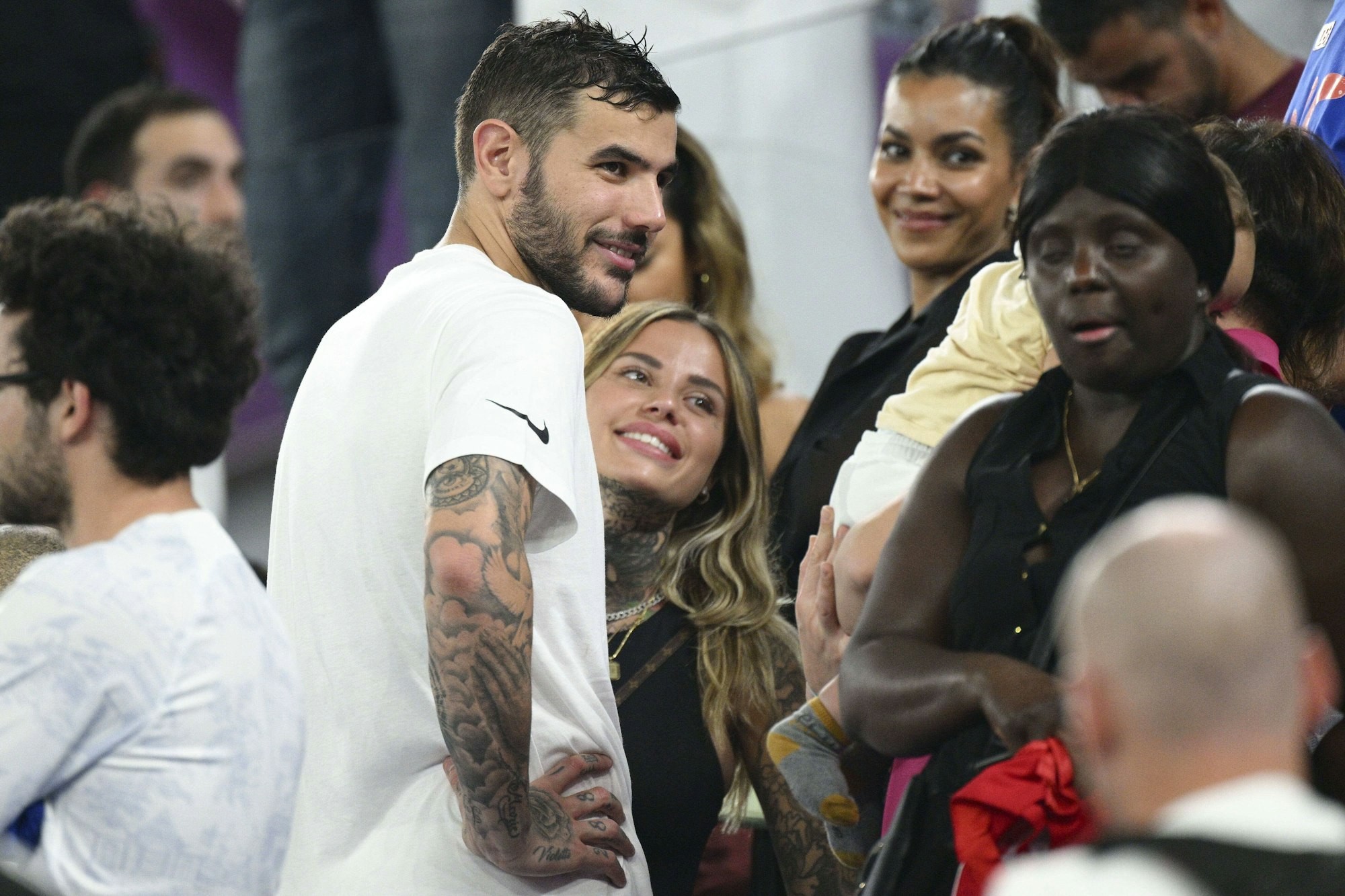 Theo Hernández und Partnerin Zoe Cristofoli lachen auf der Tribüne.