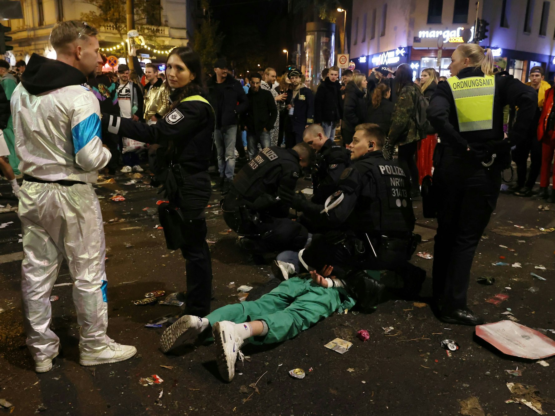 Ein feiernder Jeck wird auf der Zülpicher Straße festgenommen.