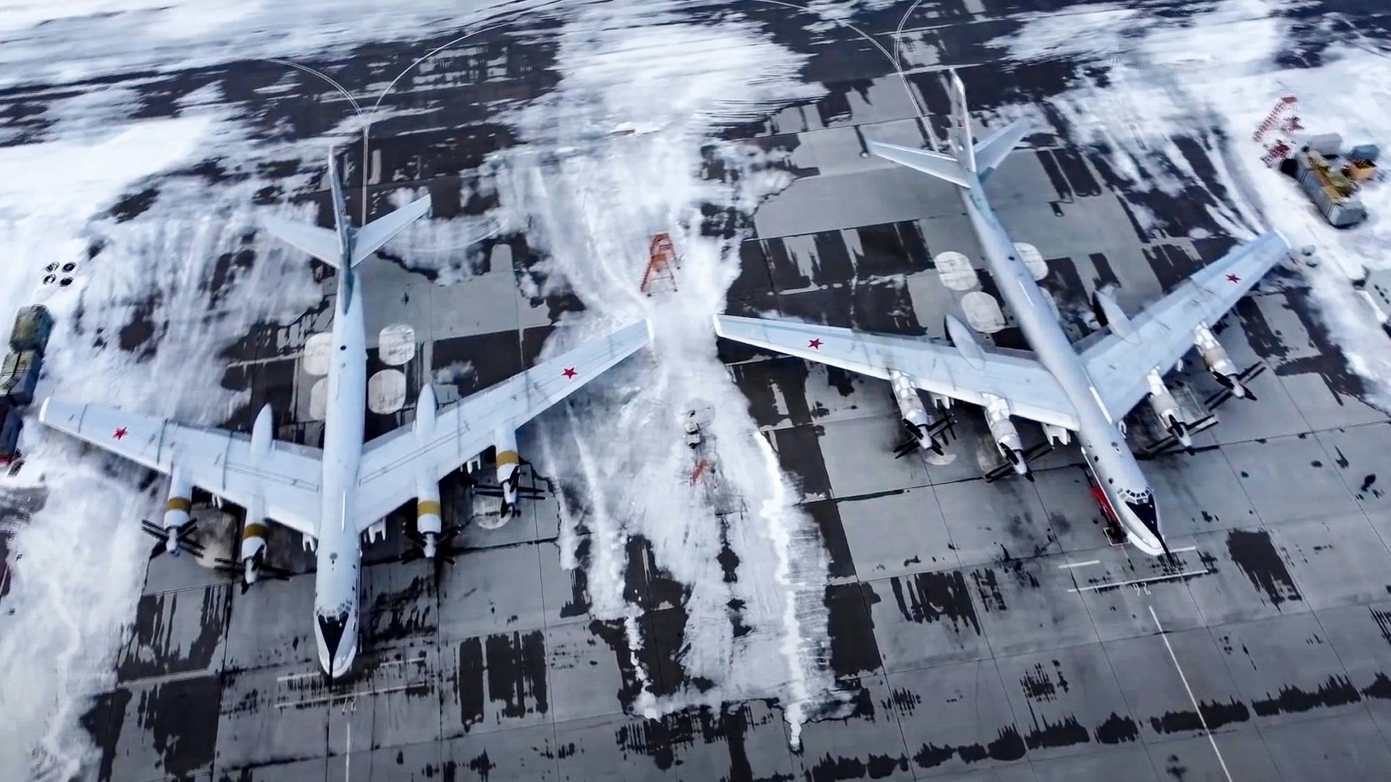 Auf diesem vom Pressedienst des russischen Verteidigungsministeriums zur Verfügung gestellten Videostandbild vom Januar 2022 sind zwei strategische Tu-95-Bomber der russischen Luftwaffe auf einem Luftwaffenstützpunkt geparkt. Auf dem Flugfeld ist Eis und Schnee zu sehen.