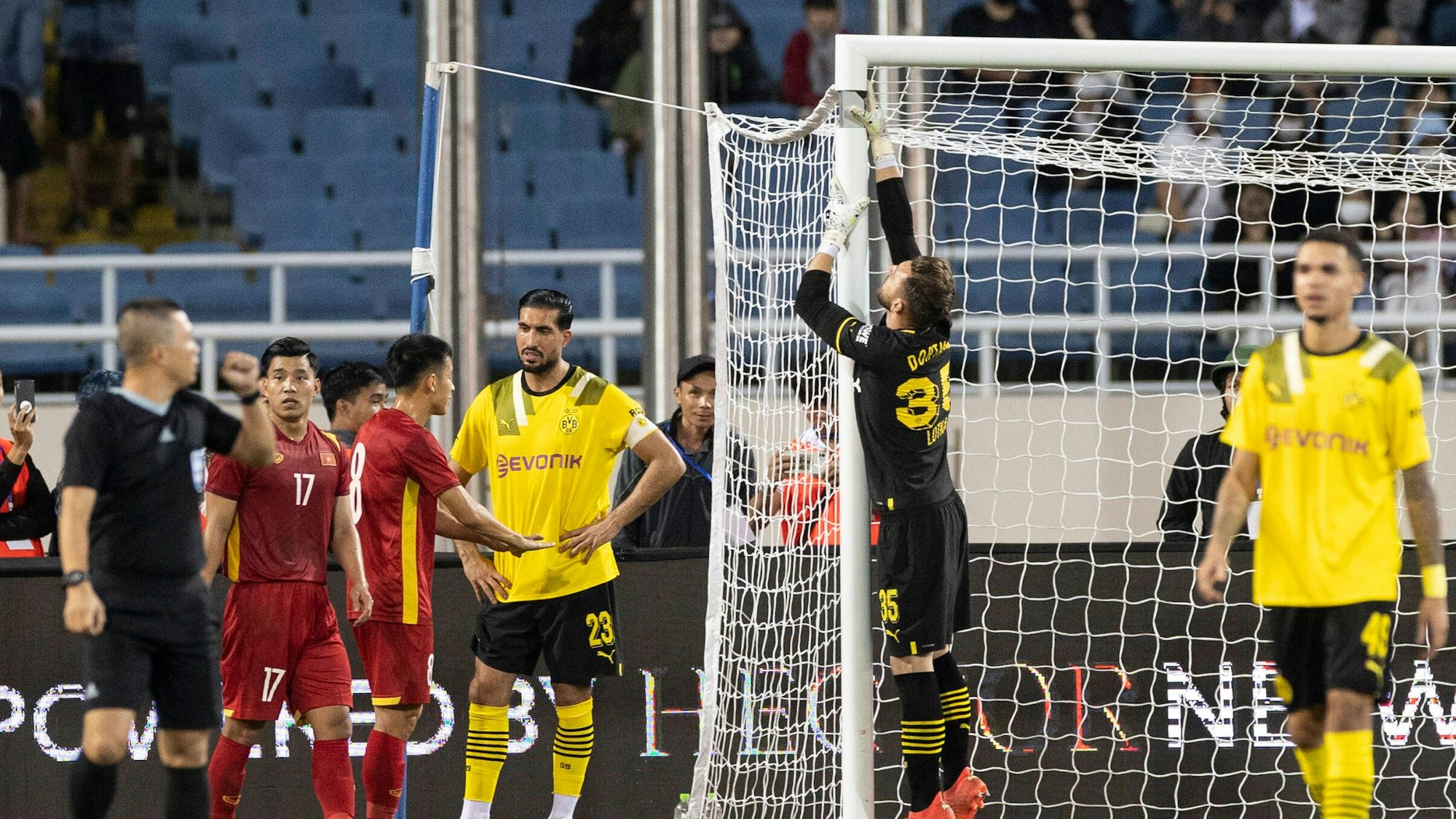 Marcel Lotka von Borussia Dortmund berührt das Torgestänge mit seinem Handschuh und versucht, ein kaputtes Tor zu reparieren.