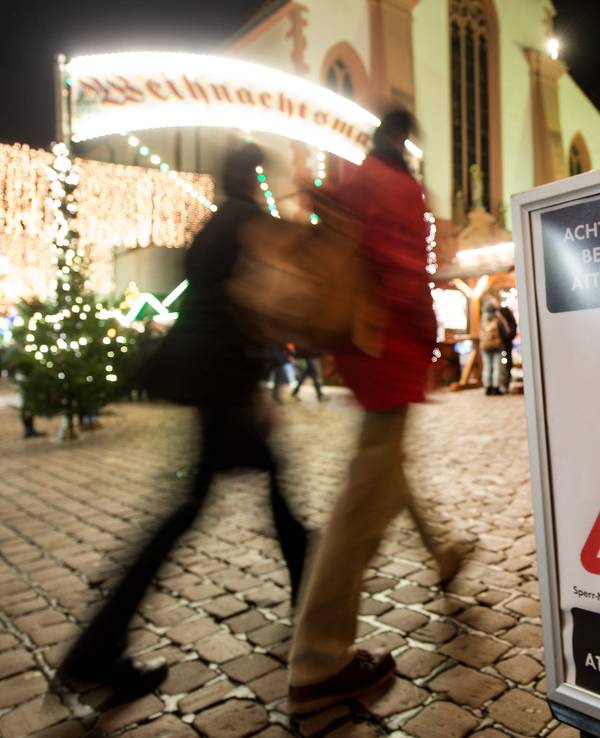 Symbolbild: 27.11.2017, Baden-Württemberg, Freiburg: Menschen gehen über den eröffneten Weihnachtsmarkt. Ein Schild warnt vor Taschendieben.