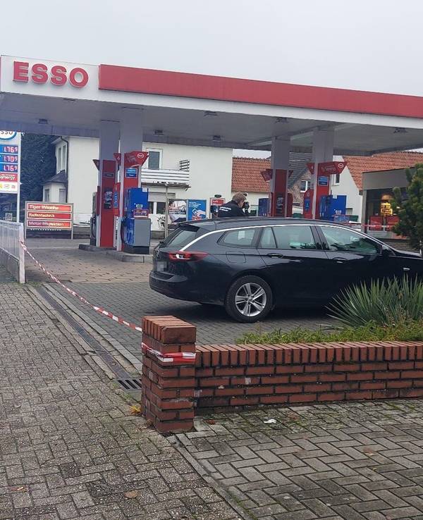Ein Polizeifahrzeug steht vor einer Tankstelle.