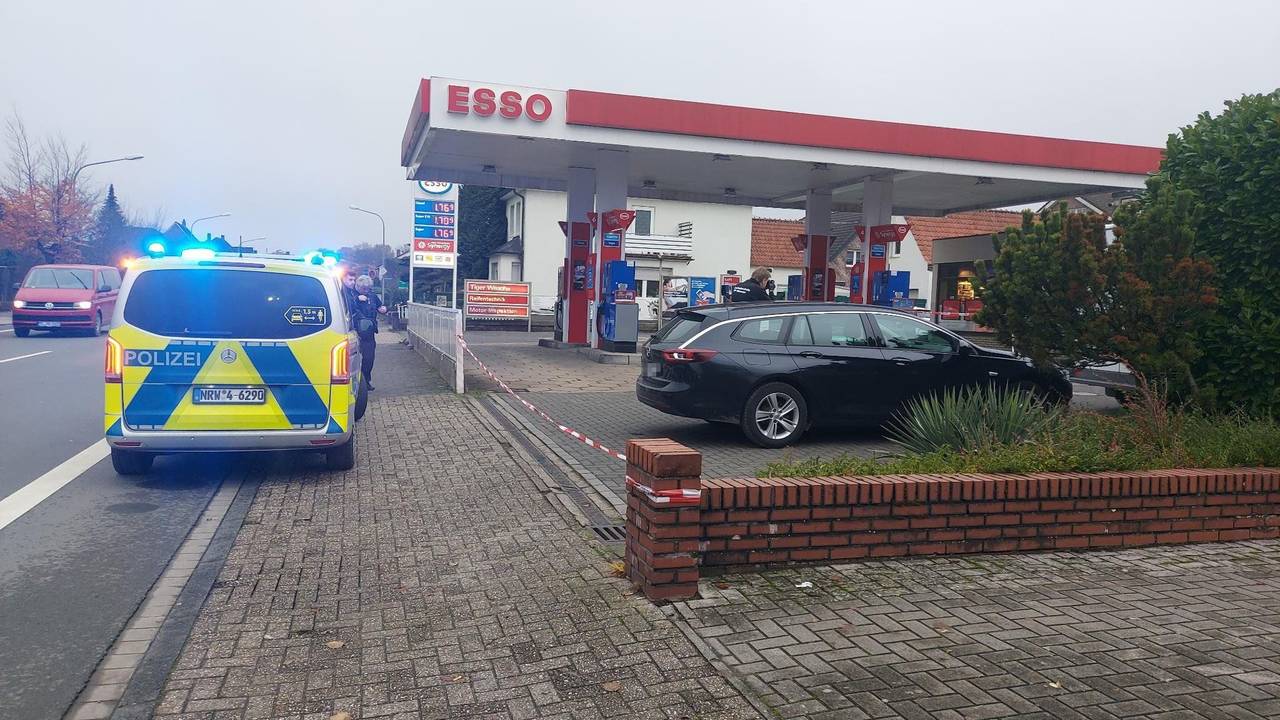 Ein Polizeifahrzeug steht vor einer Tankstelle.