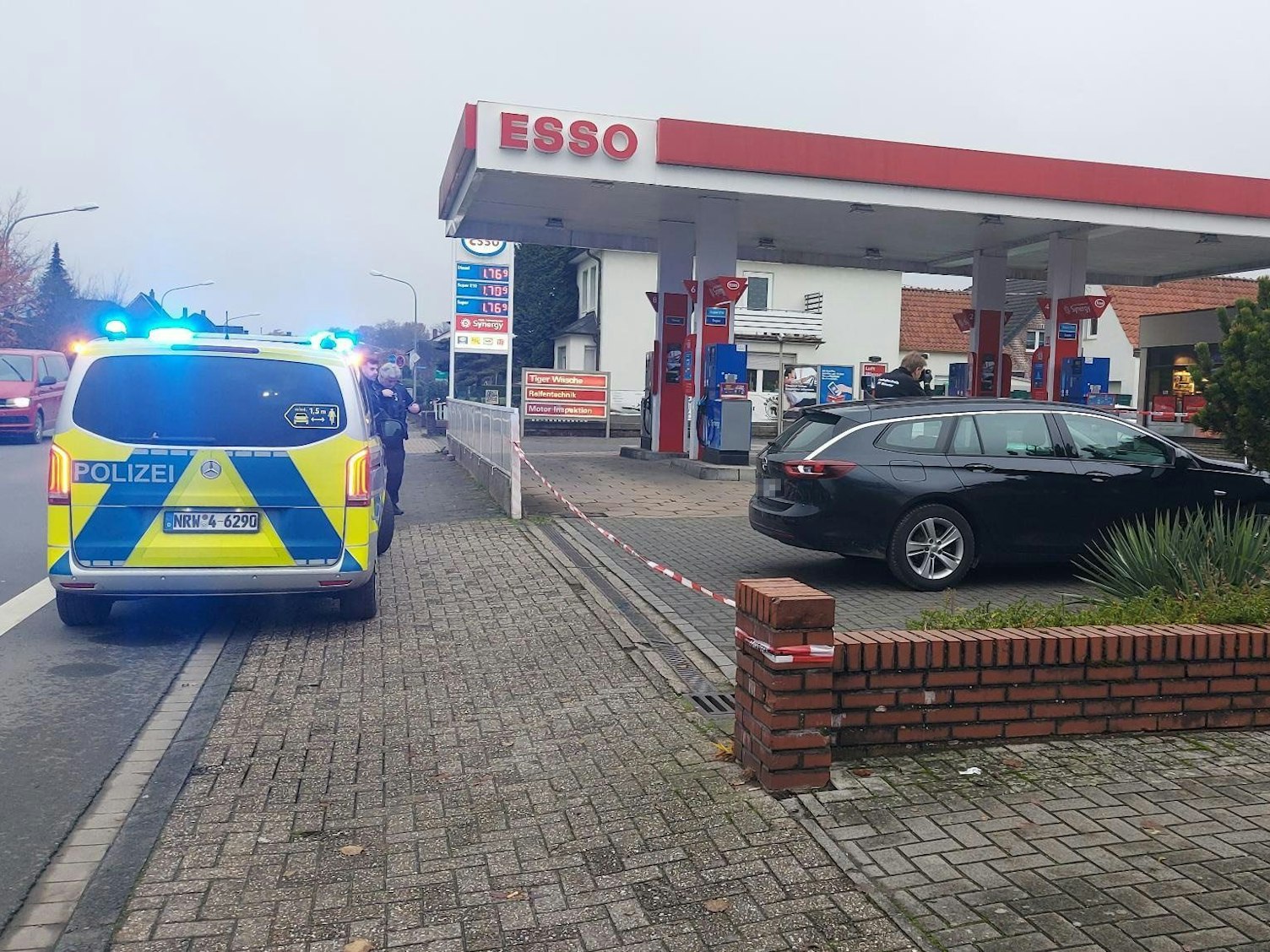 Ein Polizeifahrzeug steht vor einer Tankstelle.