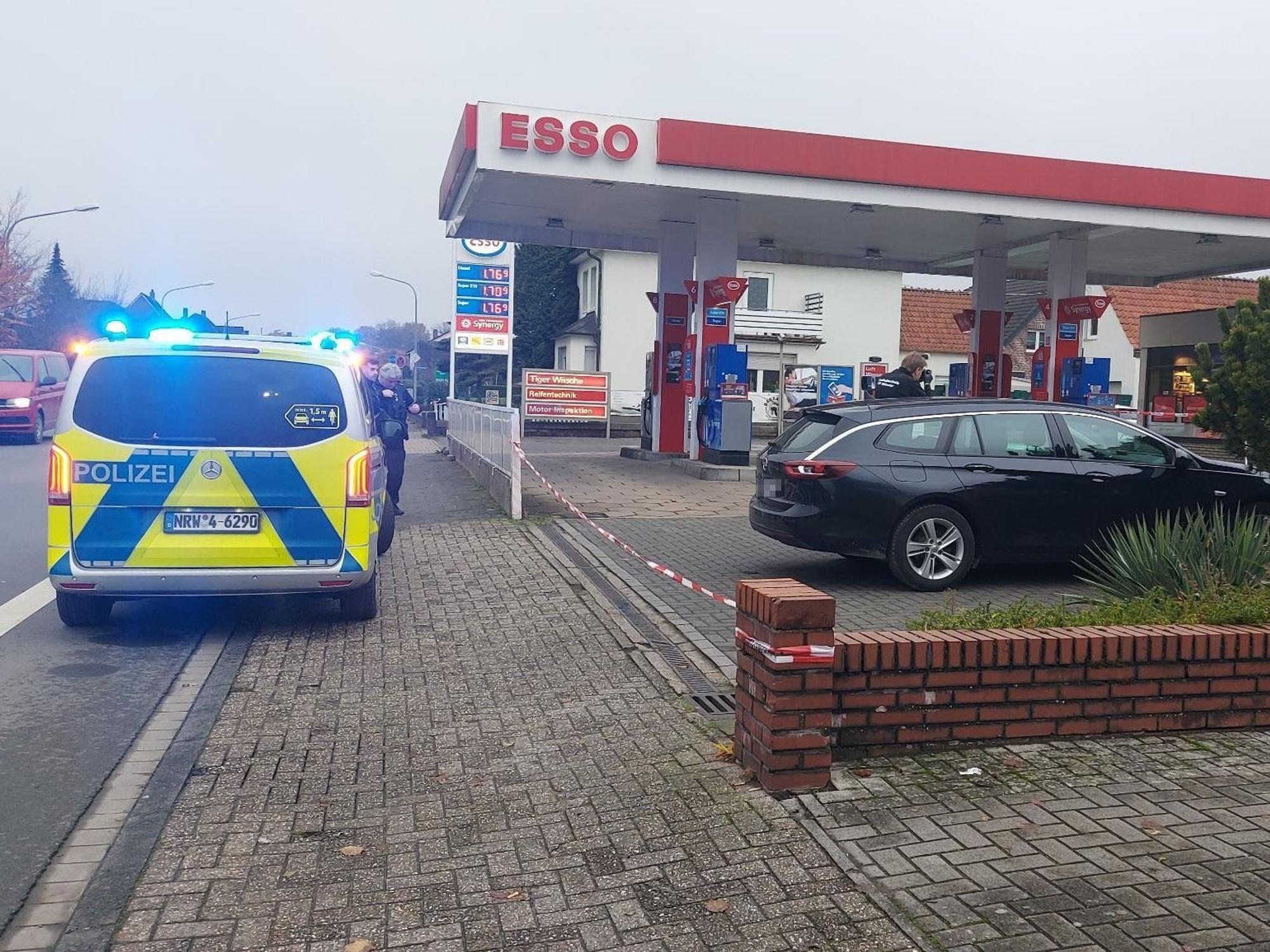 Ein Polizeifahrzeug steht vor einer Tankstelle.